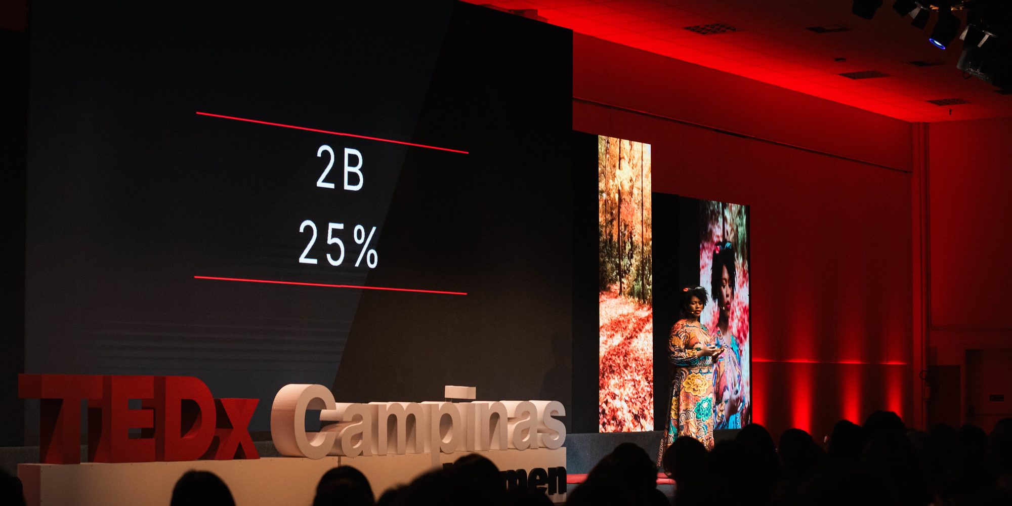 Remi Owadokun on stage at TEDxCampinasWomen in front of a full auditorium